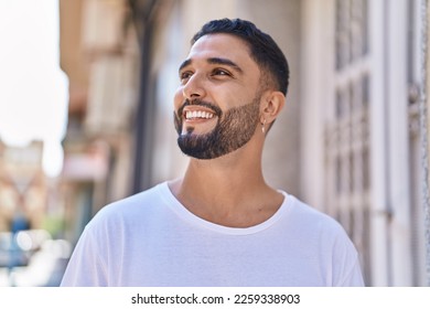 Young arab man smiling confident looking to the side at street - Powered by Shutterstock
