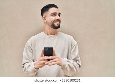 Young arab man smiling confident using smartphone over white isolated background - Powered by Shutterstock