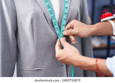 Young arab man tailor measuring jacket at tailor shop - Powered by Shutterstock