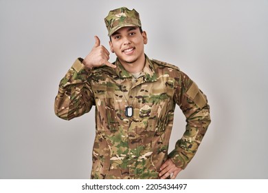 Young Arab Man Wearing Camouflage Army Uniform Smiling Doing Phone Gesture With Hand And Fingers Like Talking On The Telephone. Communicating Concepts. 