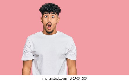 Young Arab Man Wearing Casual White T Shirt Afraid And Shocked With Surprise And Amazed Expression, Fear And Excited Face. 