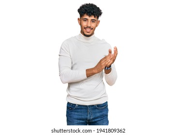 Young Arab Man Wearing Casual Winter Sweater Clapping And Applauding Happy And Joyful, Smiling Proud Hands Together 