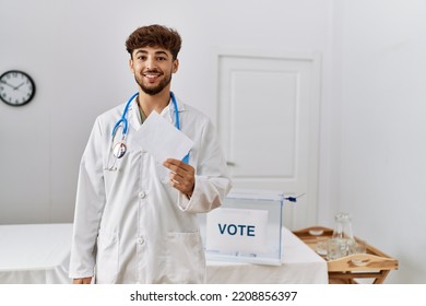 Young Arab Man Wearing Doctor Uniform Holding Vote At Electoral College