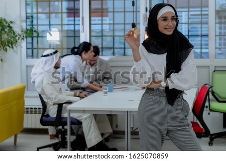 Young arabian muslim woman in hijab black clothes hold in hand holding bitcoin. Cryptocurrency exchange