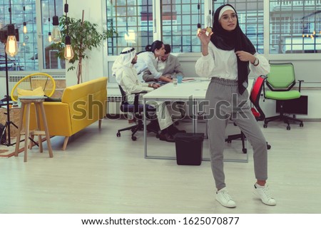 Young arabian muslim woman in hijab black clothes hold in hand holding bitcoin. Cryptocurrency exchange