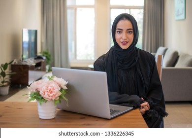 Young Arabic business woman wearing hijab with laptop at home