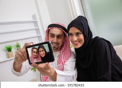 Young Arabic Couple Taking Selfie At Sofa - Powered by Shutterstock