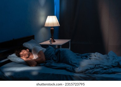 Young arabic man sleeping in bed at home at night. People, bedtime and rest concept. Copy space - Powered by Shutterstock