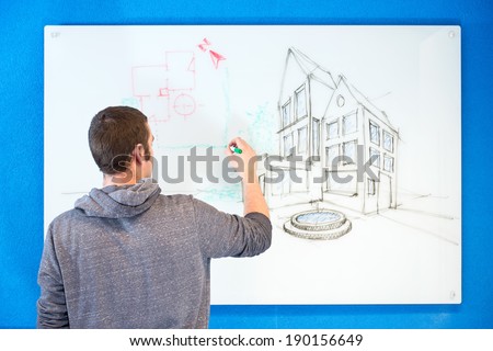 Young architect, drawing ideas, plans and concepts in an isometric perspective on a white board