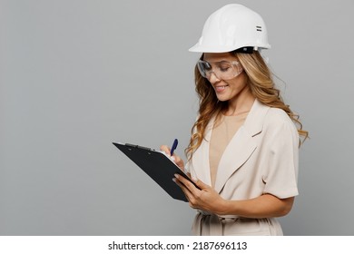 Young Architect Engineer Designer Employee White Woman 30s She Wear Pastel Clothes Hardhat Sign Document Isolated On Plain Light Grey Background Studio Portrait. People Work On Architecture Project