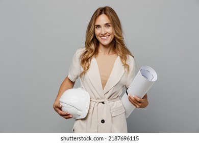 Young architect engineer designer employee white woman 30s she wear pastel clothes hold blueprints hardhat isolated on plain light grey background studio portrait. People work on architecture project