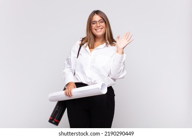 Young Architect Woman Smiling Happily And Cheerfully, Waving Hand, Welcoming And Greeting You, Or Saying Goodbye