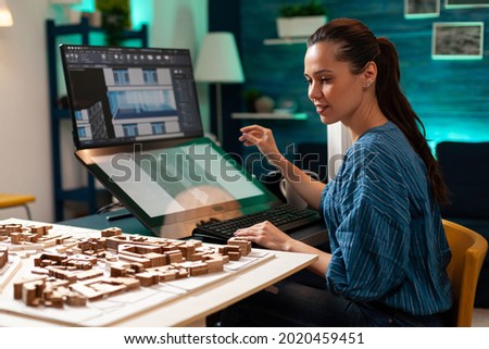 Young architect working on building miniature maquette for remodelling futuristic project. Professional designer using touch screen monitor computer technology for digital modern plan [[stock_photo]] © 