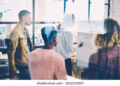 Young architects in casual outfit listening interesting workshop in office.Professional coach drawing examples of building sketches on desk during training brainstorming in university interior - Shutterstock ID 1012215037