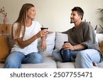 Young Argentinian couple drinking yerba mate relaxing at home living room. Lifestyle concept.