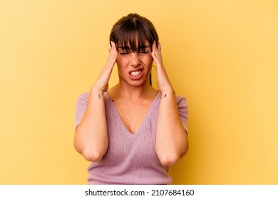 Young Argentinian woman isolated on yellow background touching temples and having headache.