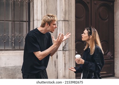 Young arguing sad couple two friends family man woman in casual clothes screaming scolding together walking outdoor near door of home. Man yelling at woman. Couple arguing, having relationship problem