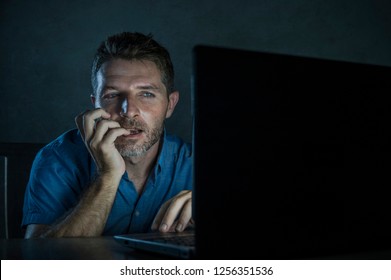 young aroused and excited sex addict man watching porn mobile online in laptop computer light night at home desk in pornography addiction and internet pornographic content concept