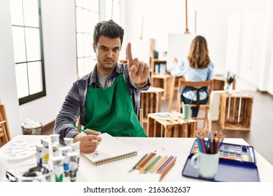 Young Artist Man At Art Studio Pointing With Finger Up And Angry Expression, Showing No Gesture 