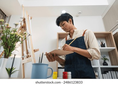 Young Artist Painting in Modern Studio with Natural Light and Art Supplies - Powered by Shutterstock