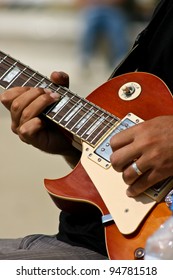 Young Artist Plays Guitar Outside In The Park