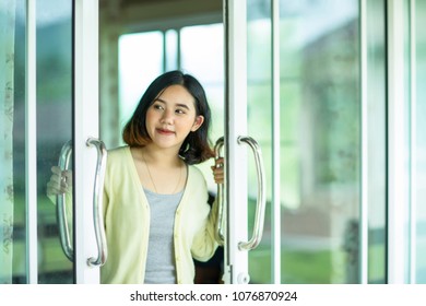 Young Asain Girl Opening The Glass Door 