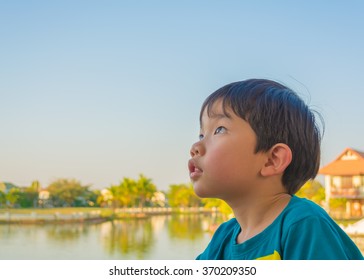 Young Asia Boy Looking On Left Side In The Park On Day Time.