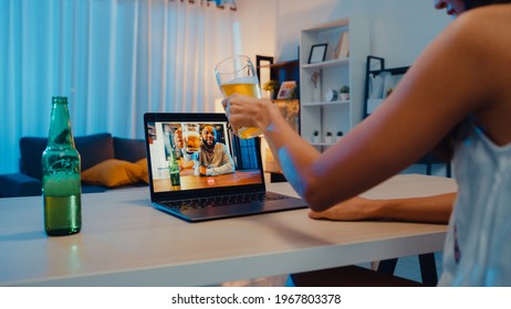 Young Asia Female Drinking Beer Having Fun Happy Moment Night Party Event Online Celebration Via Video Call In Living Room At House At Night. Social Distancing, Quarantine For Coronavirus Prevention.