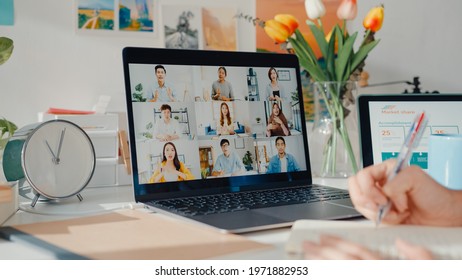 Young Asia Female Employee Listen Leader On Video Call With Diverse Multiracial Colleagues On Online With Laptop At Home. Distance Learning. Girl Student Learn Online At House, Online Meeting Concept.