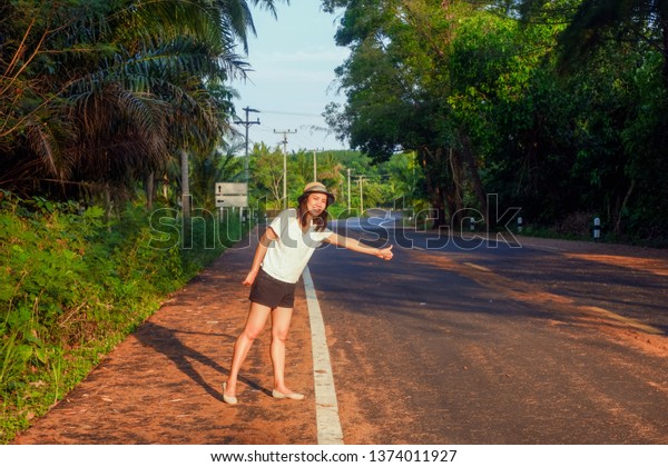 Young asia girl
stand alone on the side
road