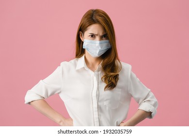 Young Asia Girl Wear Medical Face Mask With Negative Expression, Excited Scream, Crying Emotional Angry And Look At Camera Isolated On Pink Background. Social Distancing, Quarantine For Corona Virus.