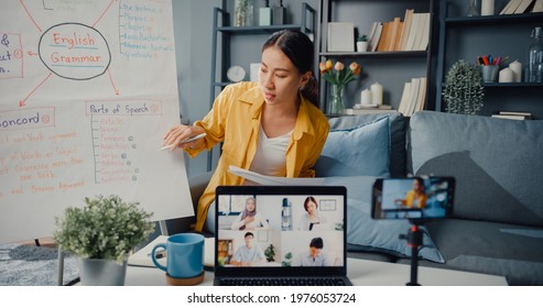Young Asia lady english teacher video conference calling on smartphone talk by webcam learn teach in online chat at home. Remote classroom, Social distancing, quarantine for corona virus prevention.