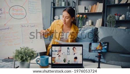 Young Asia lady english teacher video conference calling on smartphone talk by webcam learn teach in online chat at home. Remote classroom, Social distancing, quarantine for corona virus prevention.