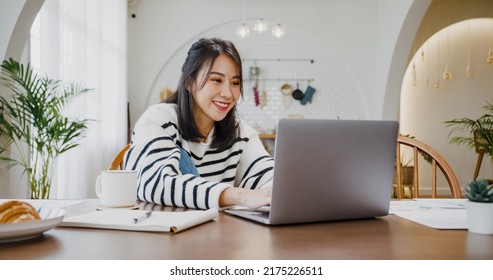 Young Asia Lady Freelance Focus On Presentation Work In Laptop For Account And Finance Project For Remote Meeting With Company In Kitchen At House. Girl Student Learn Online At Home.