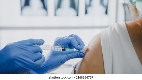 Young Asia Lady Nurse Giving Covid-19 Or Flu Antivirus Vaccine Shot To Teenage Girl Patient Wear Face Mask Protection From Virus Disease At Health Clinic Or Hospital Office. Close Up Or Closeup Shot.