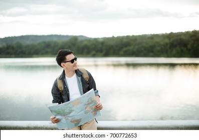  Young Asia man as he reads the map, traveling alone - Powered by Shutterstock