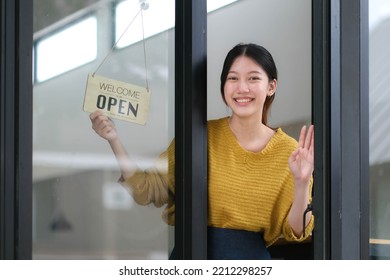 Young Asia manager girl changing a sign from closed to open sign on door cafe looking outside waiting for clients after lockdown. Owner small business, food and drink, business reopen again concept - Powered by Shutterstock