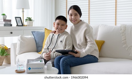 Young Asia Parents And Son Talk To Doctor On Cellphone Videocall Conference Medical App In Pediatric Care Online Telehealth Telemedicine Online Service Hospital Quarantine Social Distance At Home.