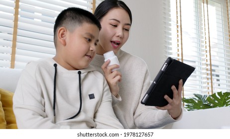 Young Asia Parents And Son Talk To Doctor On Cellphone Videocall Conference Medical App In Pediatric Care Online Telehealth Telemedicine Online Service Hospital Quarantine Social Distance At Home.