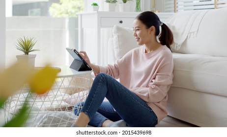 Young asia people 5G wifi digital device user teen girl watch read news play social media, e-commerce iot data app, pay money, remote shop retail store at home sofa couch sit easy relax happy smile. - Shutterstock ID 2015439698