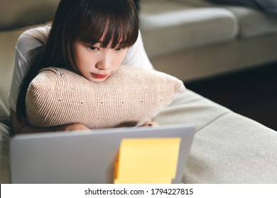 Young Asia Teenager Woman Using Internet Online Media By Laptop For Study And Social Health Care When Stay At Home From Virus Pandemic. Life With Modern Technology Concept.