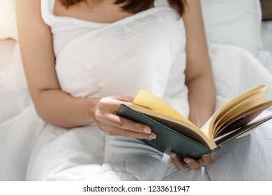 Young Asia Woman Reading Book On Bed At Her Hoom, Selective Focus.