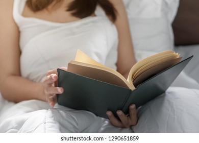 Young Asia Woman Reading Book On Bed At Her Hoom, Selective Focus.