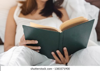 Young Asia Woman Reading Book On Bed At Her Hoom, Selective Focus.