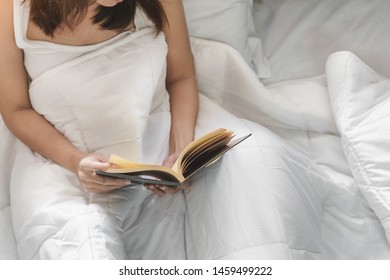 Young Asia Woman Reading Book On Bed At Her Hoom, Selective Focus.