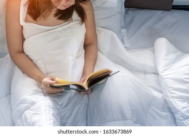 Young Asia Woman Reading Book On Bed At Her Hoom, Selective Focus.