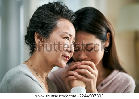 young asian adult daughter consoling senior mother living with mental illness Stock photo © 