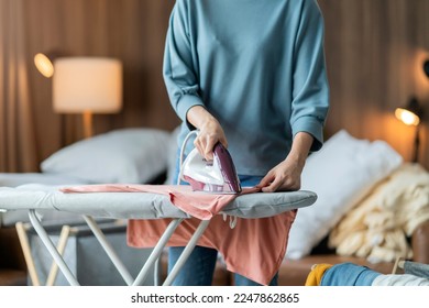 young asian adult female woman ironing her cloth at home,Portrait of a happy woman ironing her clothes at home and smiling  lifestyle concepts in living room at home housewife daily routine - Powered by Shutterstock