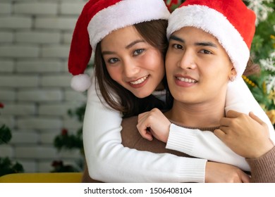 Young asian adult teenager couple hugging and  celebrateing christmas holiday together in living room with christmas tree decoration. - Shutterstock ID 1506408104