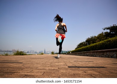 Young Asian Adult Woman Running Jogging Outdoors, Rear And Low Angle View